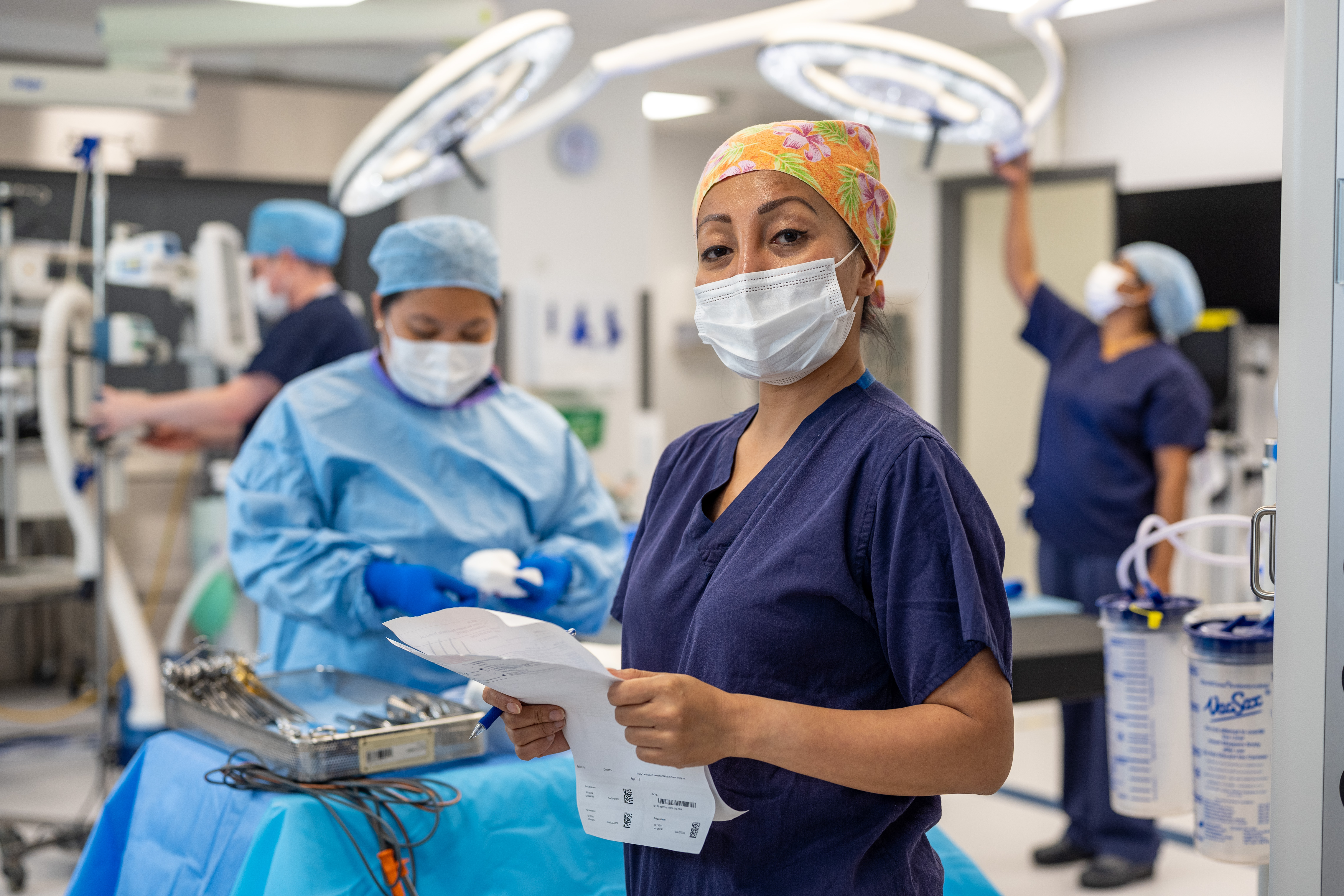 Two nurses in uniform sharing a supportive moment.