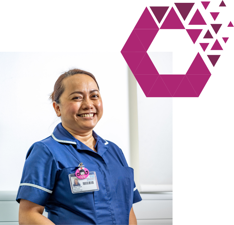 A smiling nurse in blue scrubs stands confidently in front of a white background, with a graphic purple hexagon design to her right. she wears an id badge.